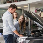 smiling-woman-checking-car-engine (1).jpg